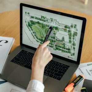 Person Using Macbook Pro on Brown Wooden Table