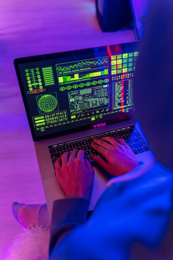 Person Using Macbook Pro on Pink Table